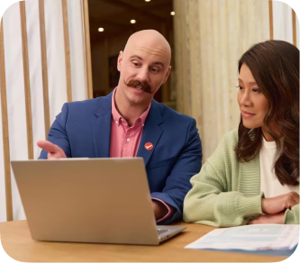 A TurboTax tax expert reviewing a return with a customer at a laptop.